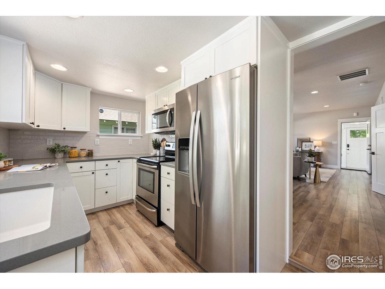 217 Locust Street Windsor, CO 80550 - Photo 14 of 40 a kitchen with a refrigerator a sink and cabinets