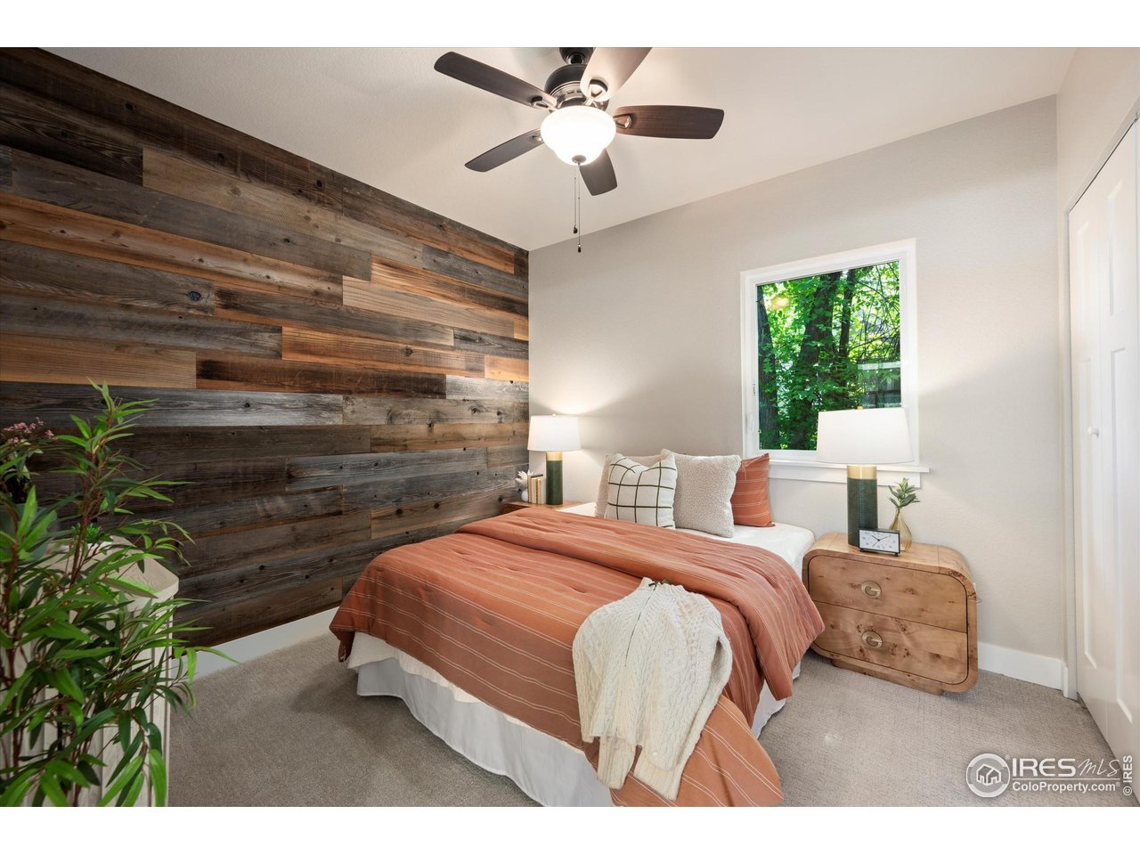 217 Locust Street Windsor, CO 80550 - Photo 16 of 40 a bedroom with a bed and a chandelier