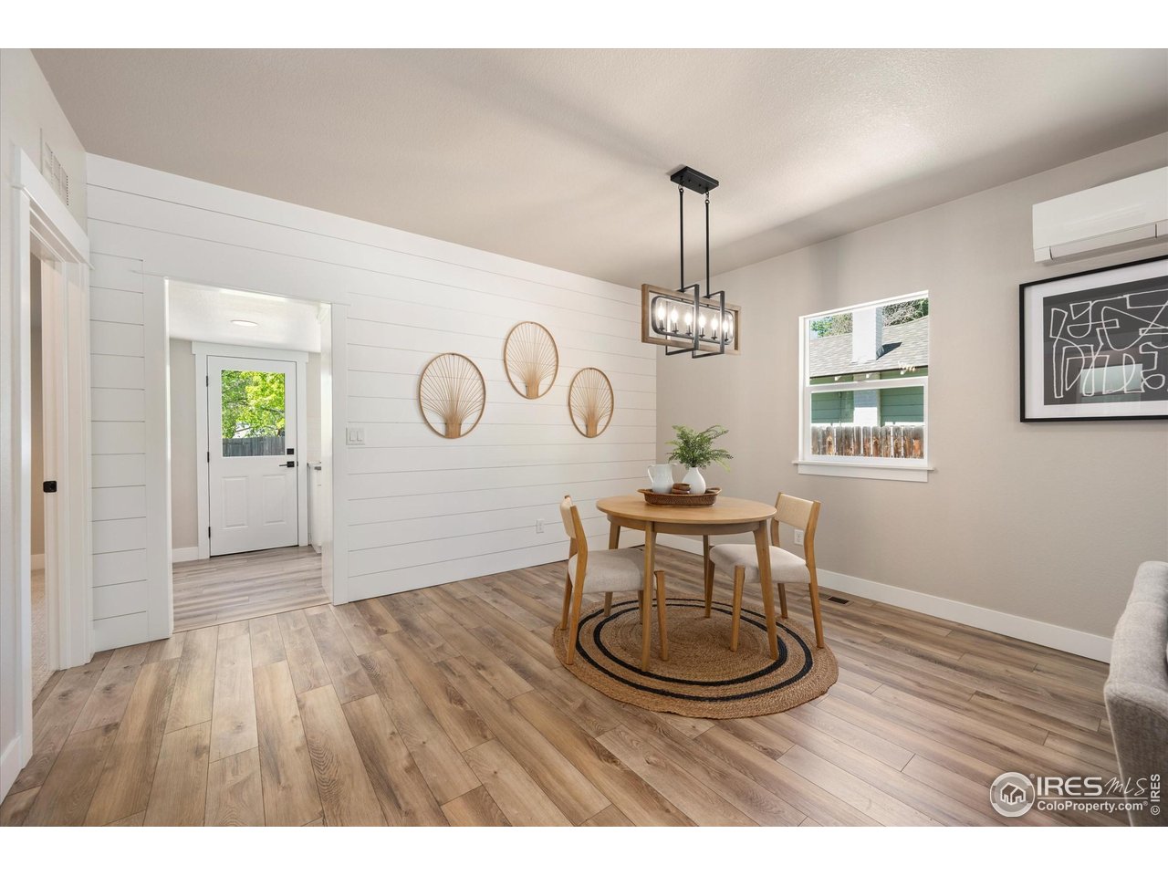 217 Locust Street Windsor, CO 80550 - Photo 9 of 40 a dining room with wooden floor a chandelier a wooden table and chairs