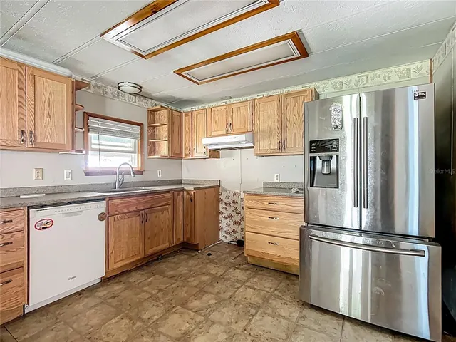 a kitchen with stainless steel appliances a refrigerator sink and cabinets