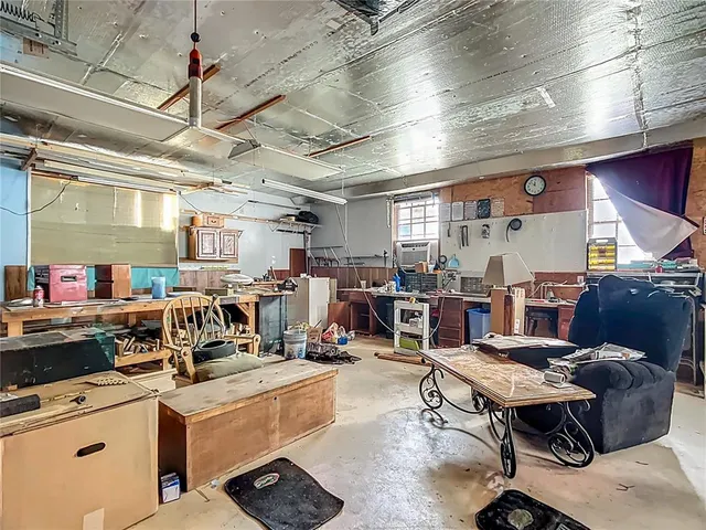 a living room with lots of furniture and clutter