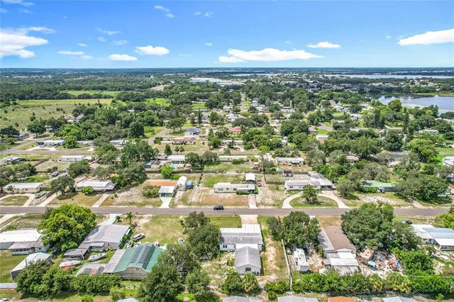 an aerial view of residential houses with outdoor space and trees