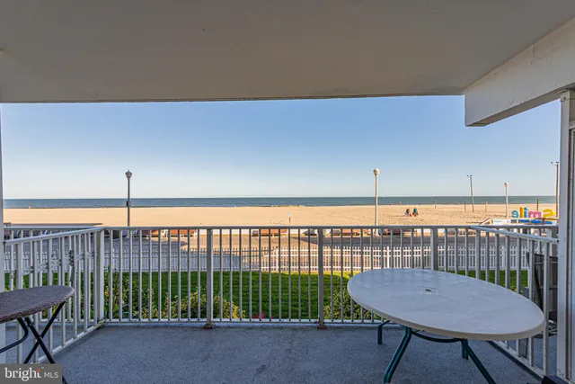 a living room with furniture and a bookshelf with wooden floor