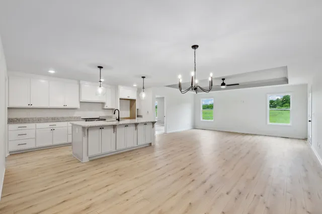 a large kitchen with cabinets wooden floor and stainless steel appliances