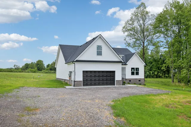 a front view of a house with a garden and yard