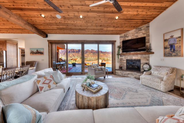 4173 Shadowfax Run, Unit 5 Moab, UT 84532 - Photo 13 of 41 Living room with sliding glass doors to outdoor living space, a vaulted wood ceiling, and floor to ceiling stone fireplace