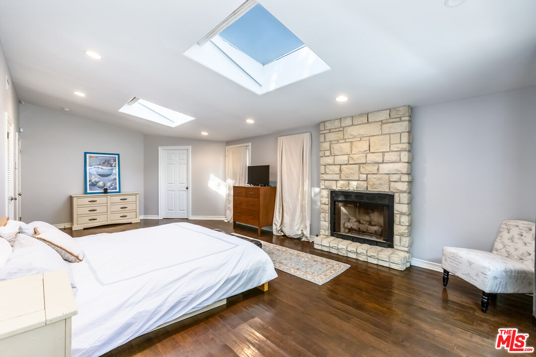 4831 Rosa Road Woodland Hills, CA 91364 - Photo 10 of 27 a spacious bedroom with a bed and a fireplace