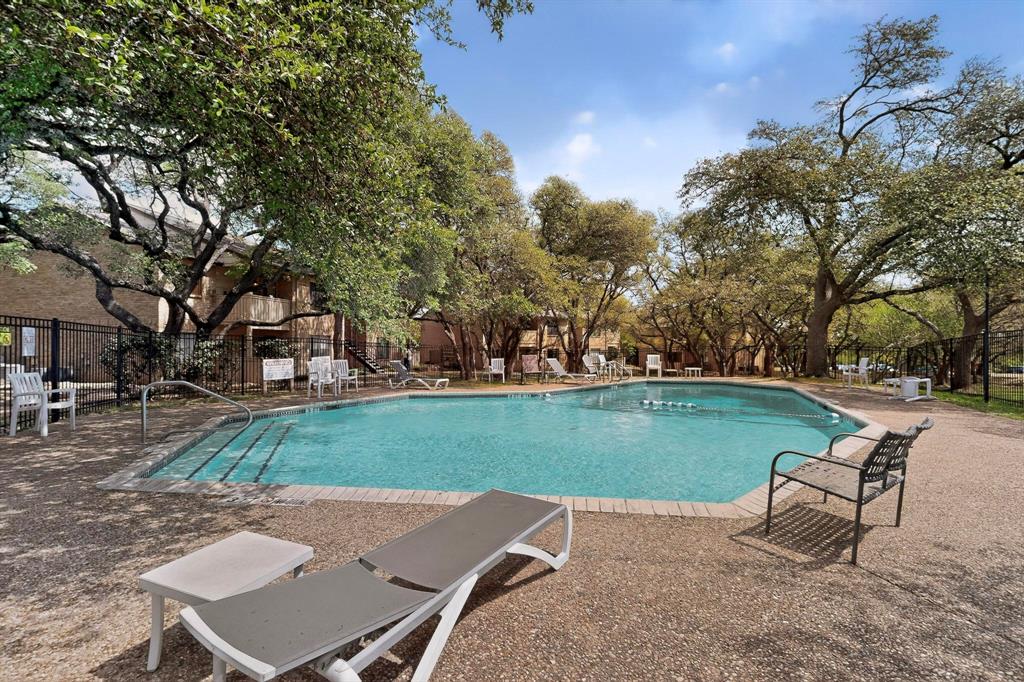 8210 Bent Tree Road, Unit 116 Austin, TX 78759 - Photo 12 of 21 Mature trees shade a community swimming pool surrounded by a paved sun deck.