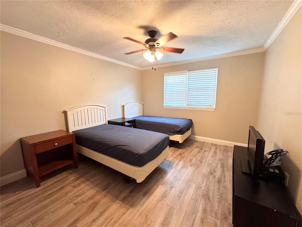 4318 Lake Underhill Road, Unit 17 Orlando, FL 32803 - Photo 7 of 12 a bedroom with a bed and wooden floor