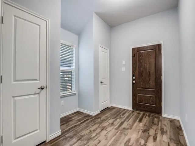 a view of an empty room with closet and a window