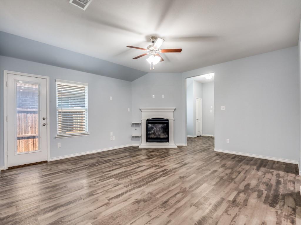 2804 Lenham Lane Forney, TX 75126 - Photo 3 of 12 a view of an empty room with wooden floor fireplace and a window