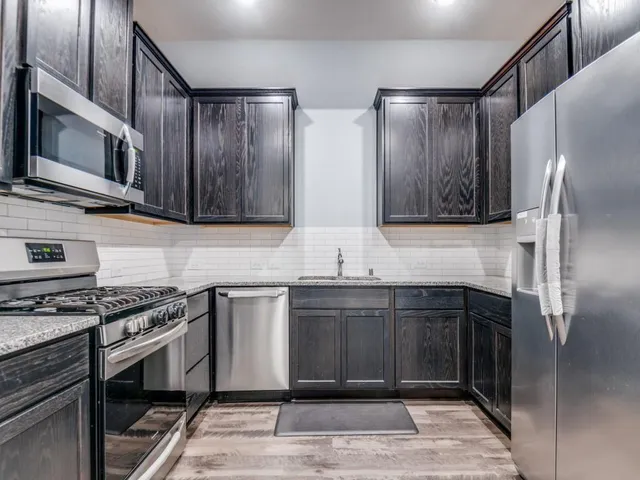 a kitchen with stainless steel appliances granite countertop a stove and a microwave