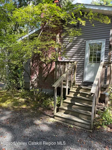 a view of house with backyard and outdoor seating