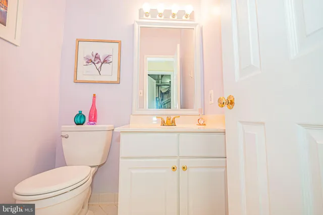 a kitchen with a refrigerator a stove a sink and white cabinets with wooden floor