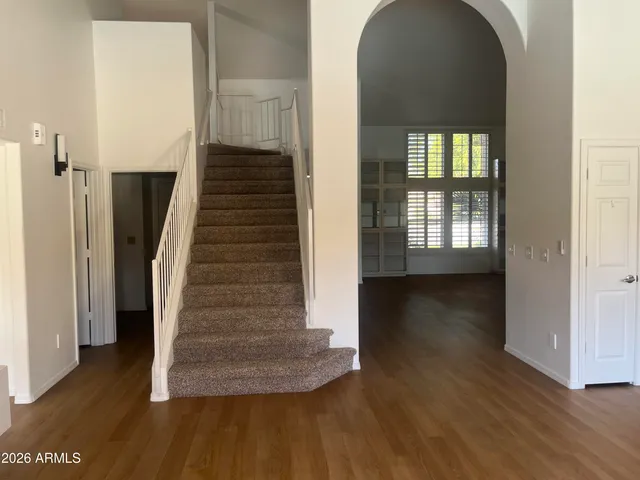 a view of a hallway with wooden floor and staircase