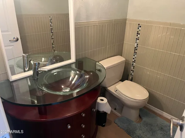 a bathroom with a sink a toilet and a mirror