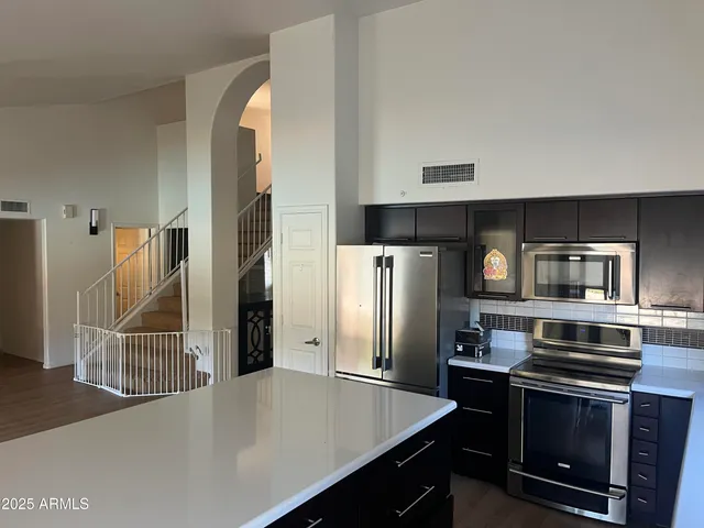a kitchen with stainless steel appliances a refrigerator stove and microwave