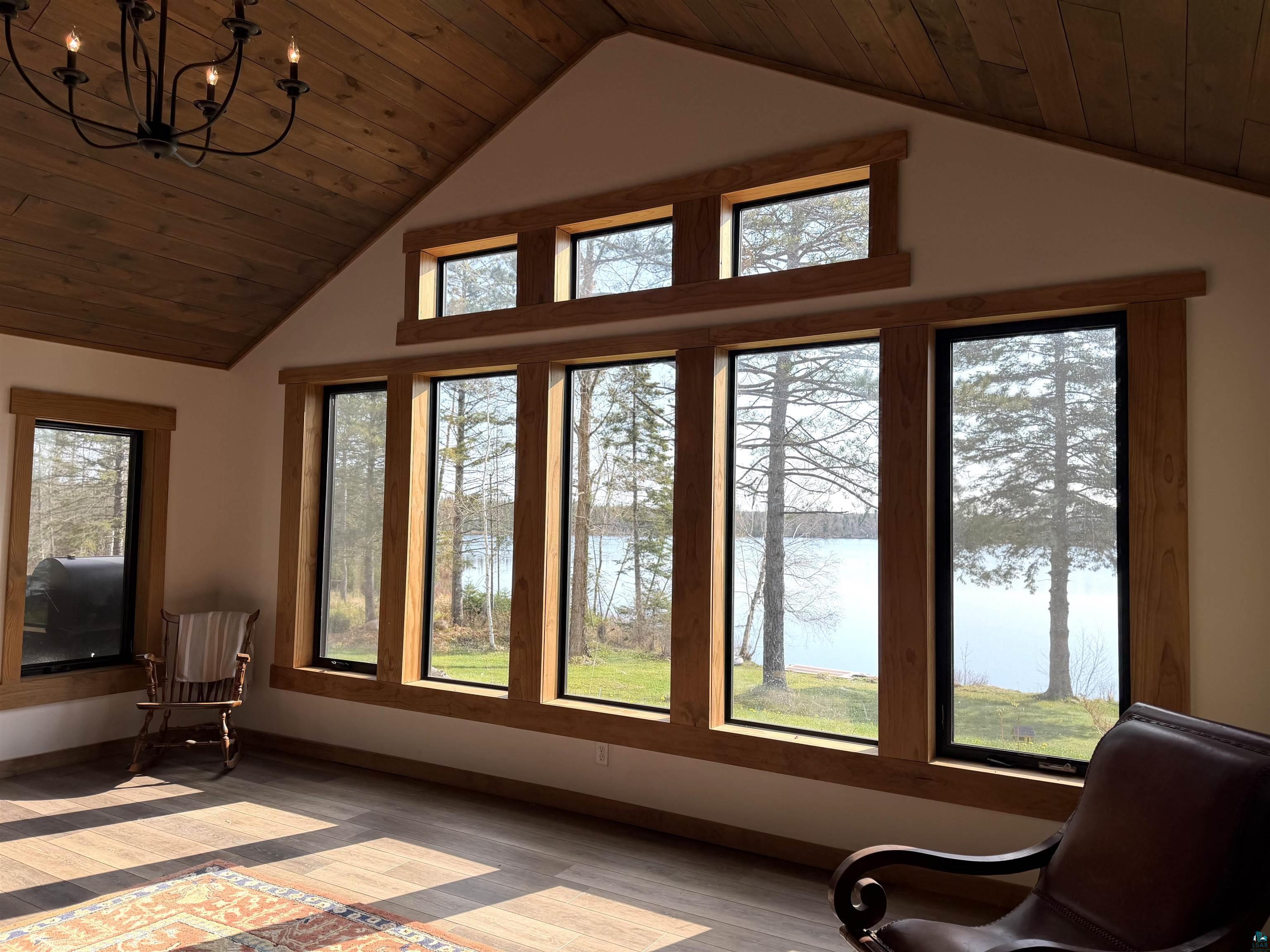 5274 Marble Lake Road Two Harbors, MN 55616 - Photo 9 of 79 Spacious interior room featuring a vaulted wood-plank ceiling and a prominent wall of windows