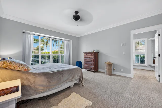 a bed sitting in a spacious bedroom next to a window