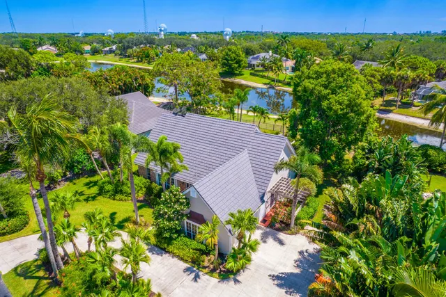 an aerial view of a house with a yard and lake view