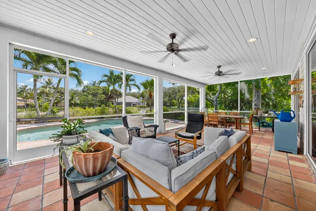 a living room with patio furniture and a potted plants