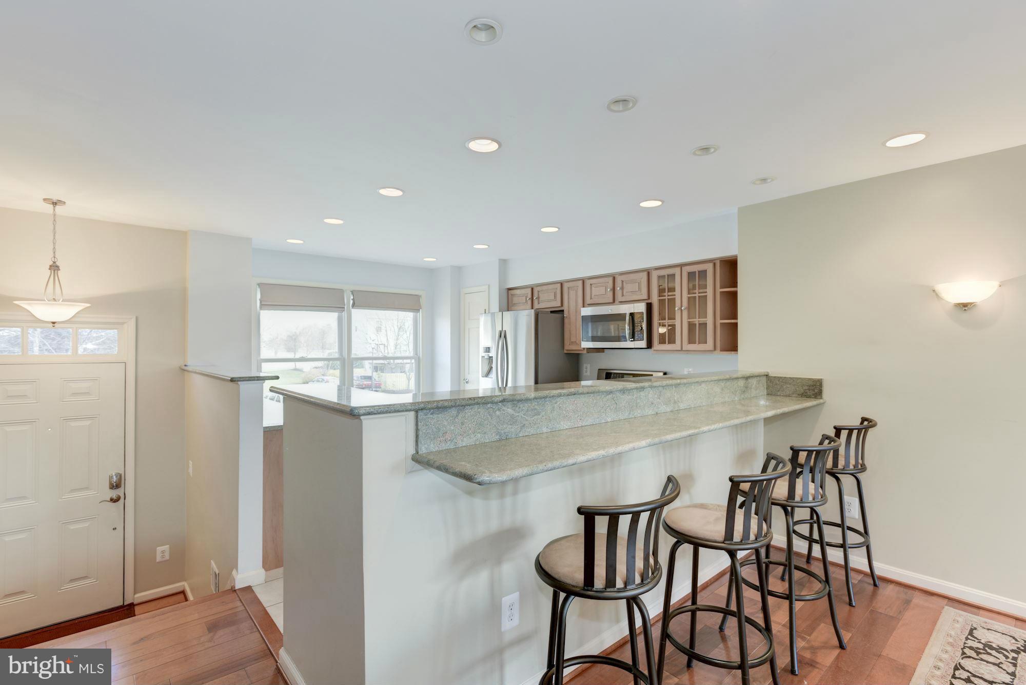 419 Davis Avenue Southwest Leesburg, VA 20175 - Photo 6 of 19 a kitchen with stainless steel appliances a dining table chairs and refrigerator