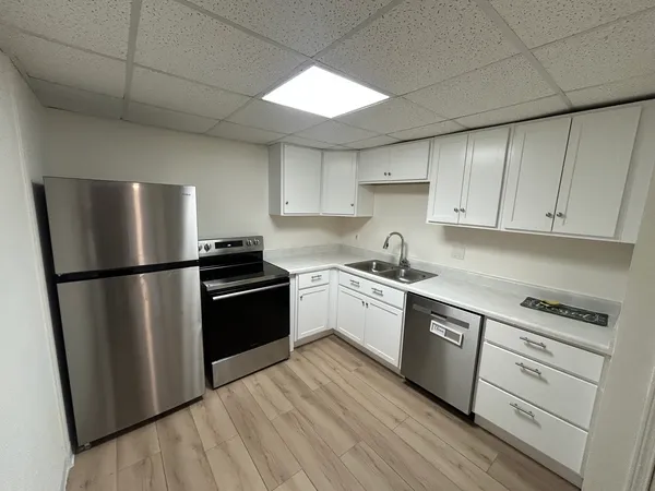 a kitchen with a refrigerator stove and white cabinets