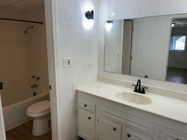 a white toilet sitting next to a bath tub