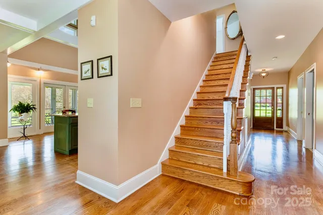 a view of a hallway with dining room and wooden floor
