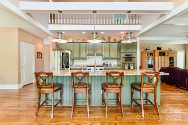 a kitchen with stainless steel appliances kitchen island granite countertop a table and chairs in it
