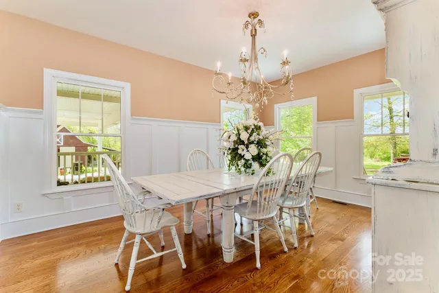 a view of a dining room with furniture a chandelier and wooden floor