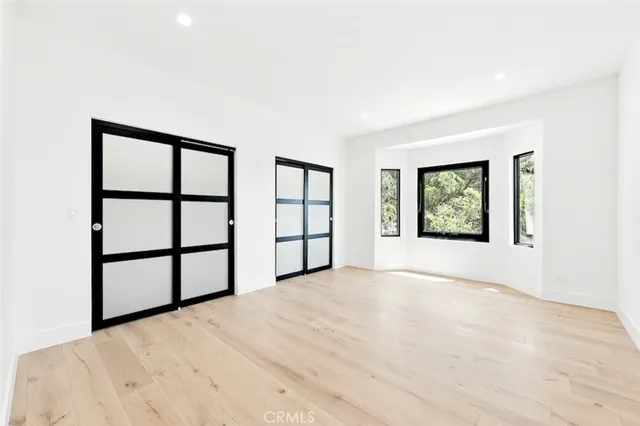 a large white kitchen with granite countertop a stove a sink and a large window