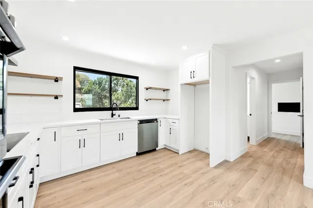 a view of a kitchen with wooden floor and electronic appliances