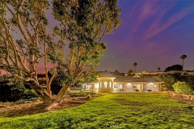 a view of a patio with couches table and chairs under an umbrella