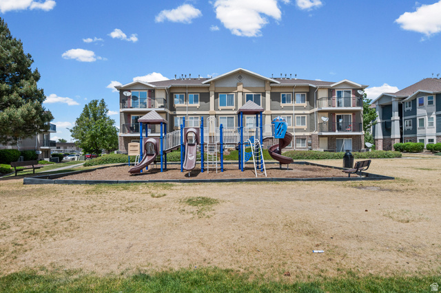 8248 South Resaca Drive, Unit J10 Sandy, UT 84070 - Photo 33 of 40 Community playground structure with slides and climbing elements, surrounded by a wood chip surface