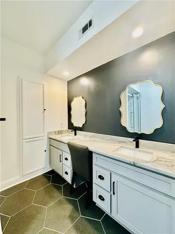 a bathroom with a granite countertop sink a toilet and a shower