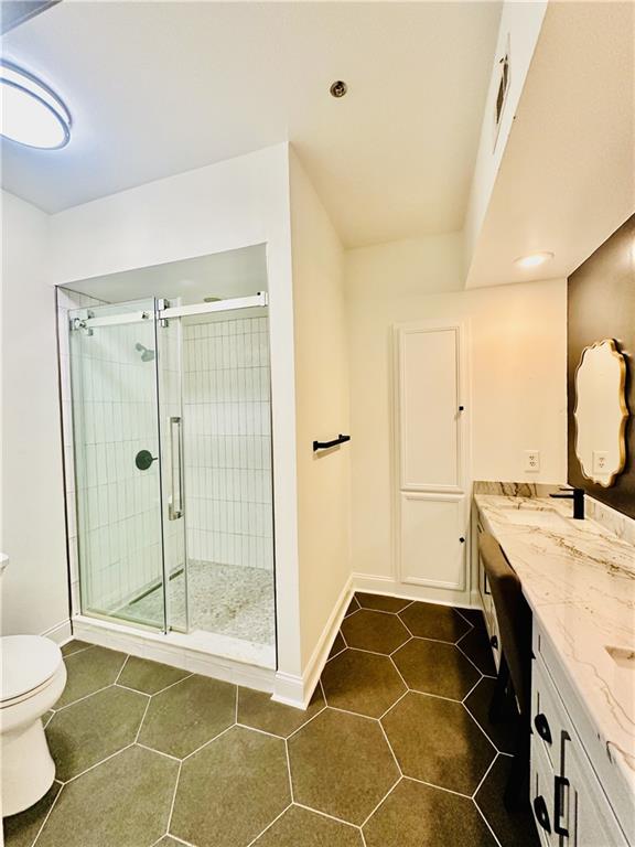 3777 Peachtree Road Northeast, Unit 1212 Atlanta, GA 30319 - Photo 12 of 25 a bathroom with a granite countertop sink a toilet and a shower