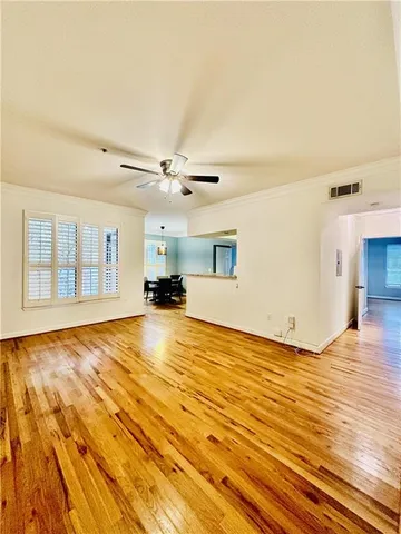 a view of a livingroom with wooden floor and a ceiling fan
