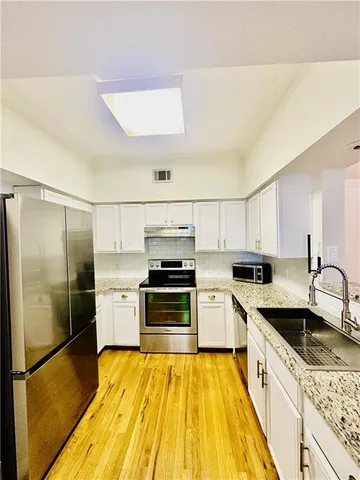 a view of an empty room and kitchen