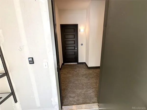 a view of a hallway with wooden floor and closet