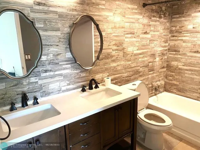a bathroom with a sink mirror vanity and toilet