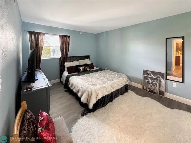 a bedroom with a bed and a dresser next to a window