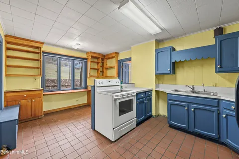 a kitchen with granite countertop wooden cabinets stainless steel appliances and a sink