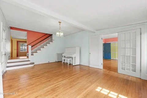 a view of an empty room with window and wooden floor