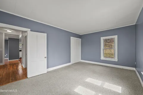 a view of a house with a small yard and large trees