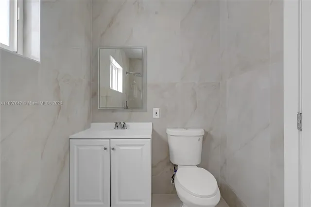 a bathroom with a toilet sink and mirror