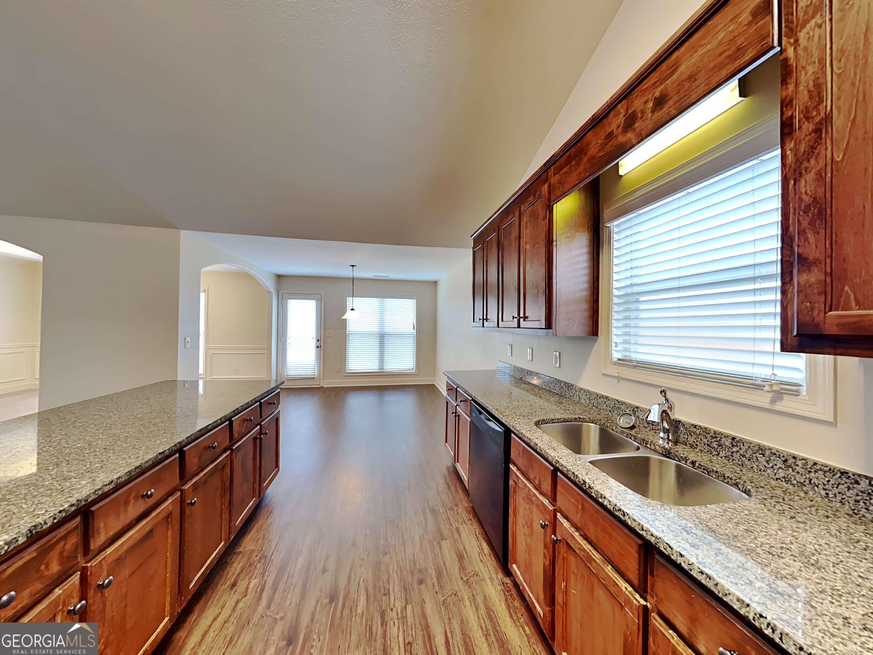 578 River Mist Circle Jefferson, GA 30549 - Photo 7 of 23 a kitchen with granite countertop a sink a counter space wooden floor and stainless steel appliances