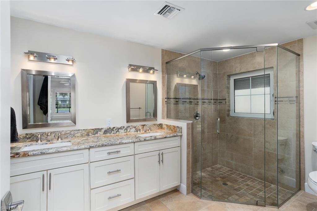 2155 Tarpon Road Naples, FL 34102 - Photo 13 of 24 a bathroom with a granite countertop sink mirror and shower