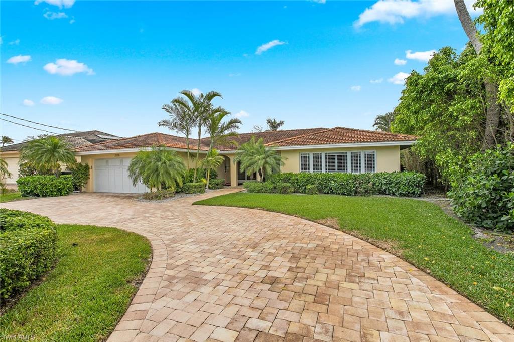 2155 Tarpon Road Naples, FL 34102 - Photo 4 of 24 a front view of a house with a yard