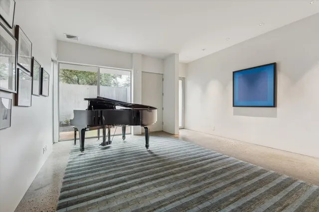 a living room with furniture and a dining table with wooden floor